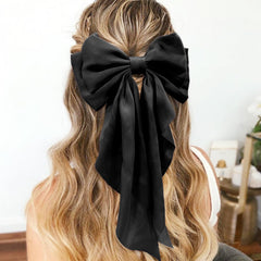 Clip para cabello de illpta con lazo satén negro, sujeción confiable.