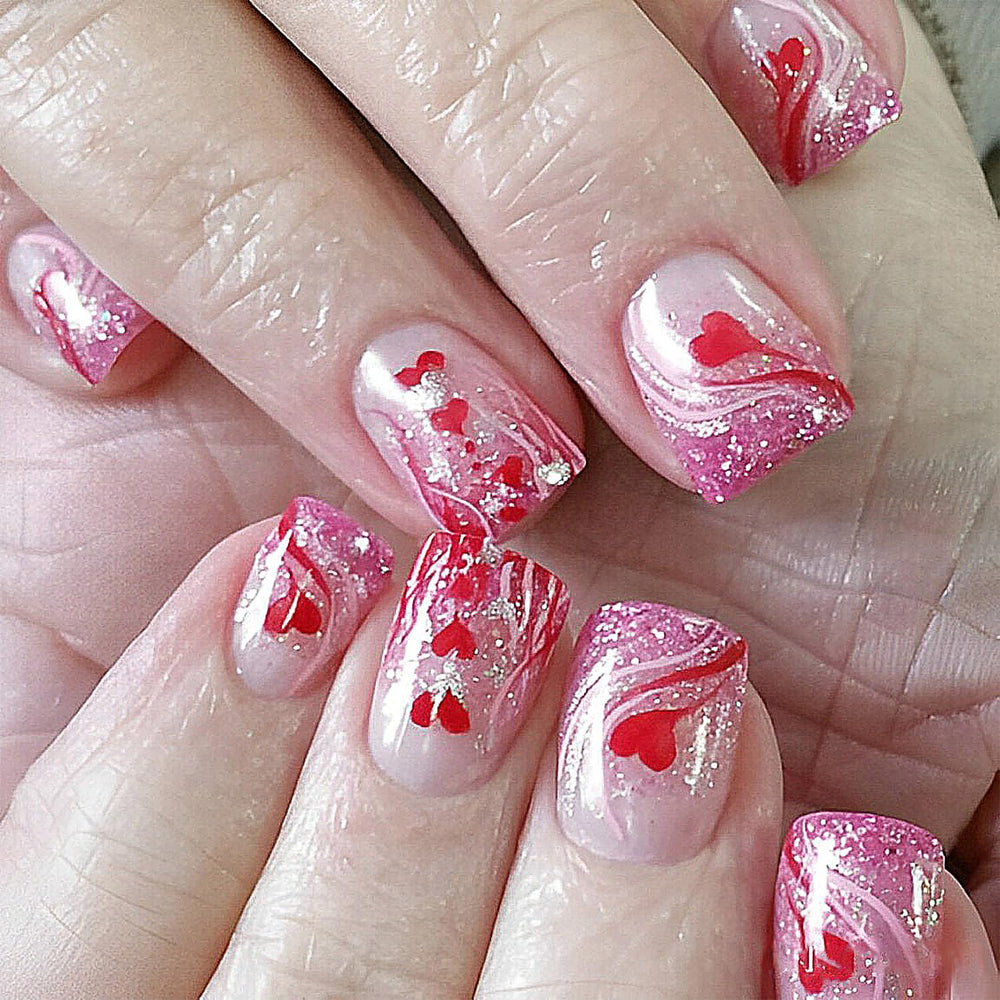 Uñas KRTBKR pegables con corazón rojo y brillo romántico.