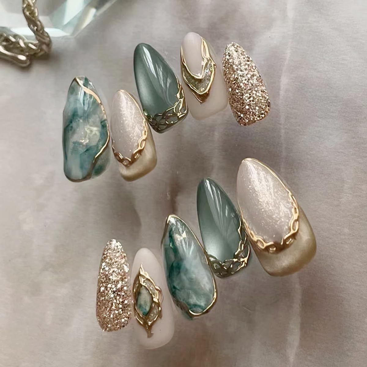 Uñas MINGCHUN con efecto ojo de gato en almendra corta y marmolado 3D para looks elegantes.
