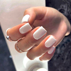 Modelones uñas postizas blancas en mano, look limpio y elegante.