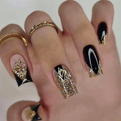 Much Hotter uñas acrílicas cuadradas con brillo dorado y negro para looks elegantes.