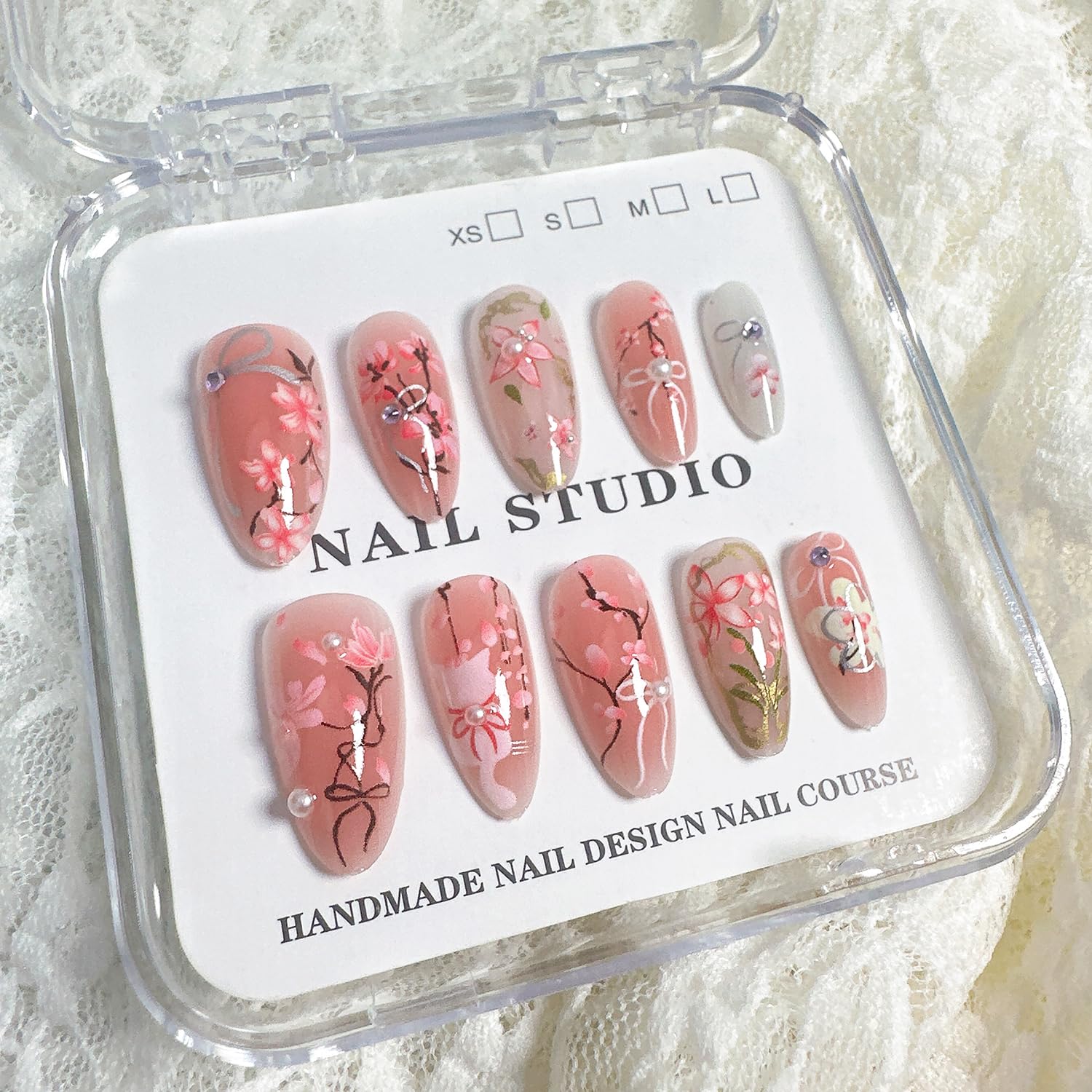 NZRAESTRS uñas con lazo rosa y cristales para un toque romántico.