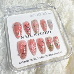 NZRAESTRS uñas con lazo rosa y cristales para un toque romántico.