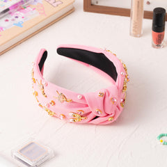 PANTIDE diadema con diseño de lazo y joyas en tono rosa.