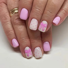 PowPop uñas postizas rosas con corazones y lazo, ideal para manicura rápida y romántica.