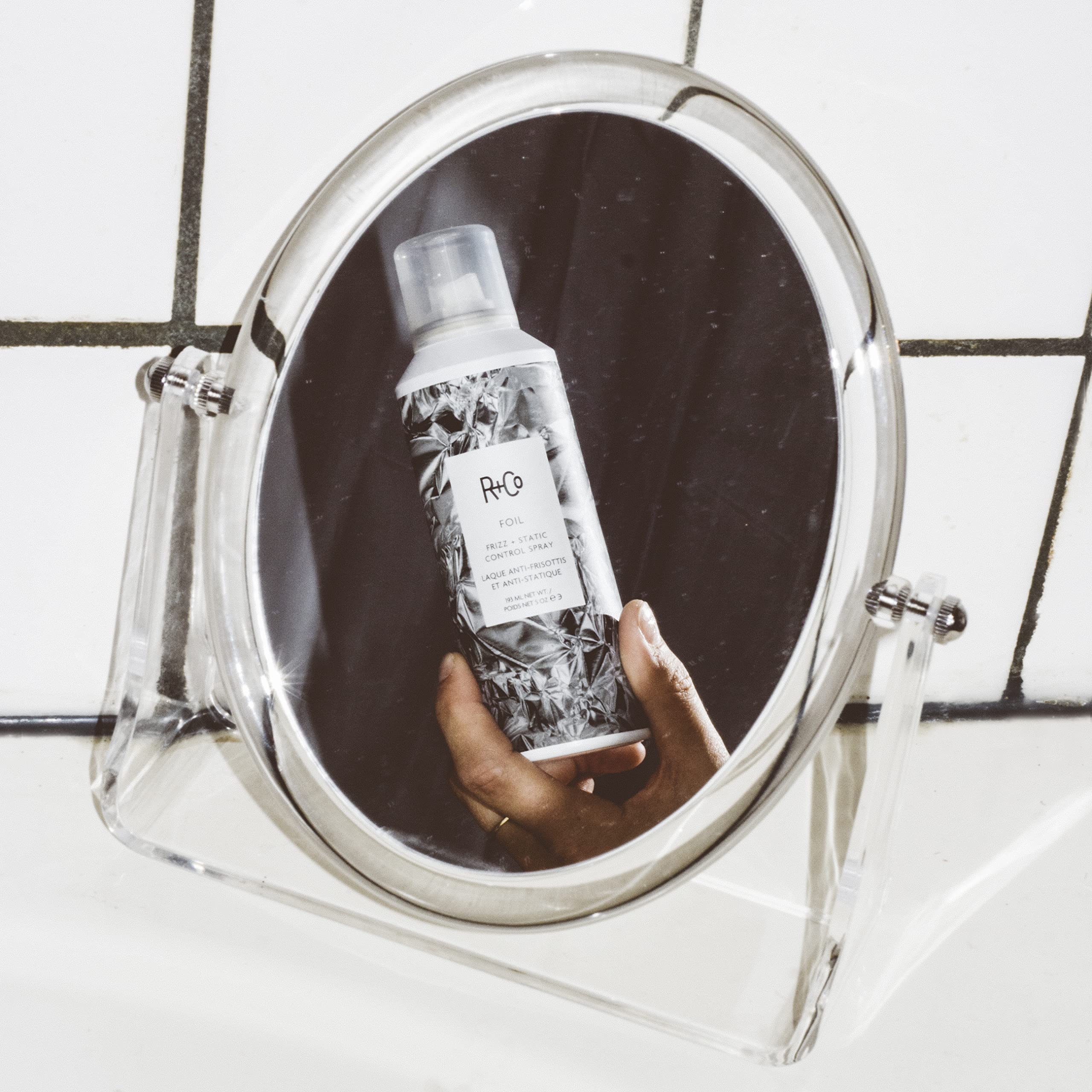 R+Co Foil Frizz + Static Spray, aplicación a mano para peinado rápido.
