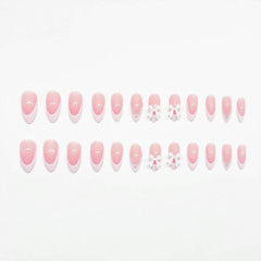 Detalle de diseño con lazo y perlas en uñas Xenophoer